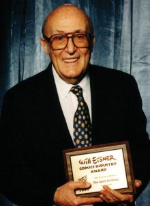 Will Eisner with his Eisner Award, for Best Archival Collection/Project, for The Spirit Archives, vols. 1 & 2 in 2001. Photo by Tom Deleon © 2012 SDCC